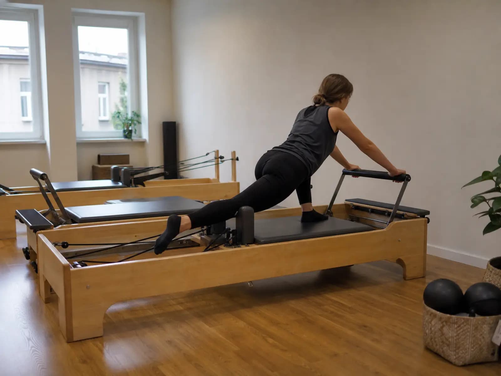 Osoba ćwiczy na reformerze w studiu pilates